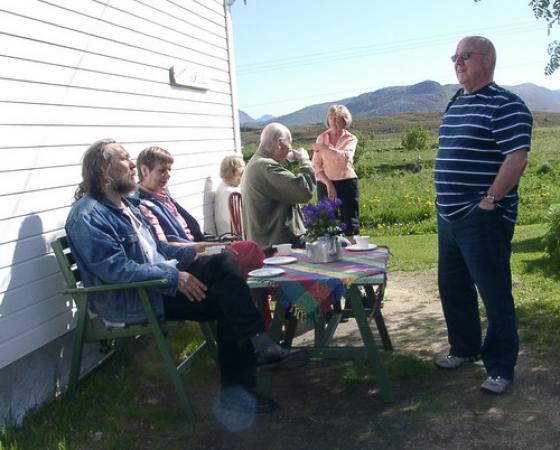 Gjestene hygger seg i solveggen med kaffe og kaker.